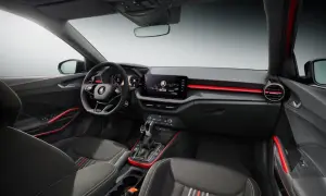 Interni sportivi della Skoda Fabia Montecarlo con sedili in tessuto, volante multifunzione e display centrale. Dettagli rossi accentuano l'abitacolo.