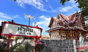 Znak "Hua Hin" przed zabytkowym budynkiem dworca kolejowego w Tajlandii.