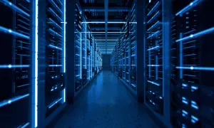 Wnętrze nowoczesnego data center z rzędami serwerów oświetlonych niebieskim światłem.