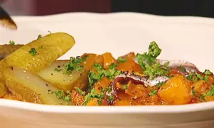 En portion pytt Bellman med stekt potatis, inlagd gurka och en ansjovisfilé.
