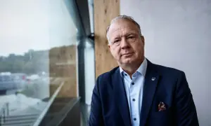 VD Volvo, en man i mörk kostym med Volvo-märke på kavajslaget, tittar mot kameran.
