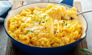 Pyszne, ciągnące się mac n cheese w niebieskiej patelni, z gałązkami tymianku. Idealne na pocieszenie.