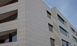 Edificio moderno con fachada de gres porcelánico para fachadas exteriores, líneas horizontales y ventanas oscuras.