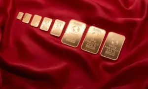 Sztabki złota Global Intergold, od najmniejszej do 100g, ułożone na czerwonym jedwabiu. Wśród nich widać combibar Valcambi.