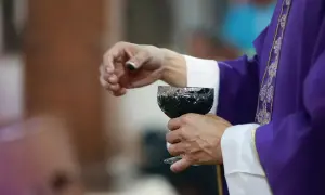 Dłoń księdza w purpurowej szacie trzyma kielich z winem. Dziś, 15 lutego, trwa ważna ceremonia.