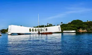 Pomnik USS Arizona w Pearl Harbor, biała konstrukcja nad wodą, upamiętnia tragiczne wydarzenia.