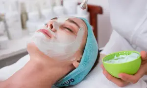 Kobieta z maseczką na twarzy, relaksująca się podczas zabiegu. To idealny moment na pielęgnację z użyciem naturalnych maseczek do twarzy.