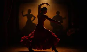 Bailarina de flamenco con vestido rojo, sombras de guitarrista y bailaora en el fondo. Escena de un documental flamenco.