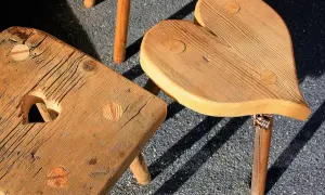 Drewniane taborety do kuchni, jeden w kształcie serca, drugi kwadratowy z wycięciem w kształcie serca.