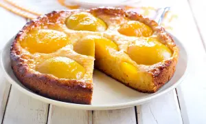 Torta soffice con pesche sciroppate dorate, un dolce profumato e invitante, perfetto per ogni occasione.