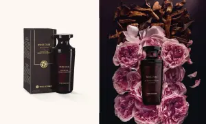 Flakon perfum Rose Oud Yves Rocher otoczony płatkami róż i drewnem oud.