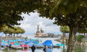 Bunte Tretboote liegen am Steg, im Hintergrund die Imperia-Statue und ein Dampfer am St. Galler See.