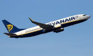 Samolot Ryanair wznoszący się na tle błękitnego nieba.