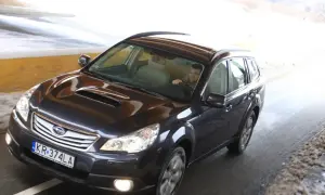Ciemny Subaru Outback 2025 jedzie przez tunel, kierowca w szaliku.