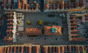 Widok z lotu ptaka na rynek w Jeleniej Górze. Widać kolorowe kamienice, kawiarniane ogródki i zabytkowy ratusz. To świetne miejsce na odkrywanie jeleniogórskich atrakcji.