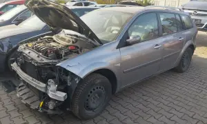 Szary kombi z otwartą maską, widoczny silnik i uszkodzony przód. Idealny, by dowiedzieć się, jak sprzedać auto na części.
