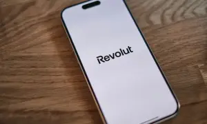 Telefon z logo Revolut na ekranie. Dowiedz się, jak wplacić pieniadze na Revolut, aby łatwo zarządzać finansami.