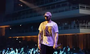 Eminem na scenie, w białej koszulce z grafiką, przed tłumem fanów. Czy to koncert w Polsce?
