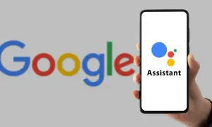 Dłoń trzyma smartfon z logo Asystenta Google. Dowiedz się, jak wyłączyć Asystenta głosowego.