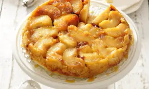 Apetyczna tarta tatin z karmelizowanymi jabłkami, podana na paterze.