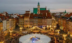 Magiczny zimowy wieczór w Warszawie. Rynek Starego Miasta rozświetlony tysiącami lampek, lodowisko i choinka tworzą idealny klimat na city break w Polsce.