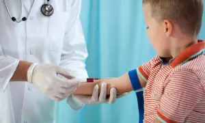 Lekarz pobiera krew od dziecka. Czas oczekiwania na badanie krwi bywa różny, ale samo pobranie jest szybkie.