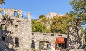 Ruinen der Hohentwiel Burg thronen auf einem Hügel. Im Vordergrund ein Torbogen und ein kleiner Kiosk.