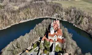 Zamek Czocha, malowniczo położony nad zakolem rzeki, otoczony lasem.
