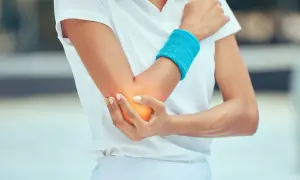 Schmerzende Ellenbeuge bei einem Sportler. Tennisarm tapen sinnvoll zur Entlastung.