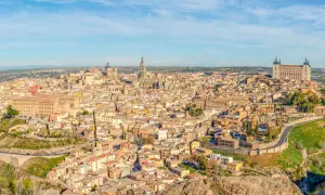 Toledo co zobaczyć: rozległa panorama miasta z katedrą i Alcázarem na wzgórzu, otoczona rzeką.