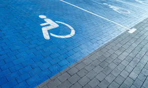 Niebieski parking z symbolem wózka inwalidzkiego. Orzeczenie o niepełnosprawności można uzyskać na wiele chorób, które ograniczają sprawność.