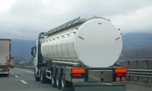 Camion-citerne blanc sur l'autoroute, prêt pour le transport. L'autorisation de rouler pour les camions est essentielle pour la logistique.
