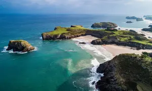 Impresionante vista aérea de la ruta costa Asturias en coche. Playas doradas, acantilados verdes y el mar turquesa crean un paisaje idílico.