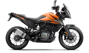 Pomarańczowy motocykl KTM 390 Adventure gotowy na przygodę, z agresywnym designem i terenowymi oponami.