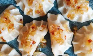 Pyszne pierogi z mięsem z rosołu, okraszone złocistą cebulką, kuszą swoim wyglądem.