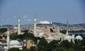 Hagia Sofia i Istanbul, en ikonisk byggnad med kupoler och minareter, reser sig mot en blå himmel.