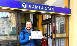 Glad guide vid Gamla Stan tunnelbanestation, redo för en guidad tur i Stockholm.