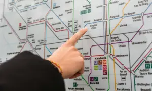 Palec wskazuje na mapę metra, szukając drogi z lotniska Barcelona.