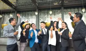 Radosna impreza firmowa! Ludzie w eleganckich stylizacjach świętują, wznosząc kieliszki szampana.