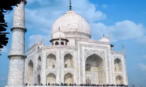 Biały marmur Taj Mahal, jeden z najpiękniejszych zabytków w Indiach, lśni na tle błękitnego nieba.