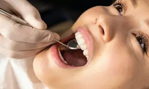 Dentysta bada zęby pacjentki, przygotowując się do zabiegu gingiwektomii.