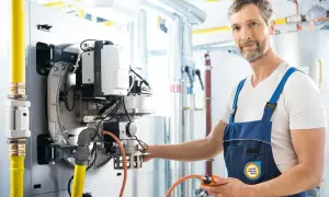 Fachmann prüft Gasleitung, verlegt sie nach Vorschriften der TRGI. Gelbe Gasleitung und Heizungsanlage im Fokus.