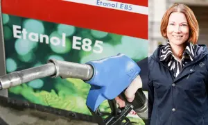 En kvinna ler vid en pump för etanol E85.