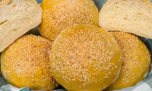 Koszyk pełen puszystych bułek bez drożdży, posypanych sezamem. Idealne na kanapki i burgery.