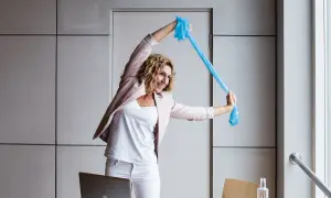 En kvinna gör en rolig pausgympa på jobbet med ett blått träningsband.