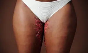 Féminité et saignement grossesse. Des paillettes rouges sur la peau, évoquant la fragilité et la vie.