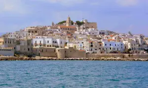 Un borgo bianco a picco sul mare, con un campanile in cima. Ricorda il vino primitivo, significato di sole e terra pugliese.