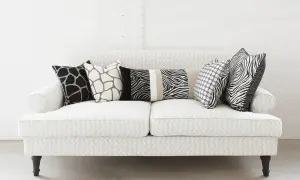 Un divano bianco con cuscini a fantasia animalier e pois: un'idea su come disporre i cuscini sul divano per un tocco moderno.
