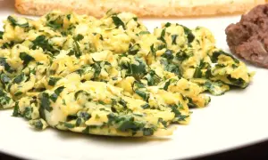 Puszysta jajecznica ze szpinakiem, podana z tostami i fasolką. Pyszne śniadanie.
