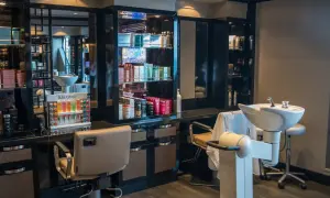 Nowoczesny salon fryzjerski. Reklama usług i produktów Kérastase. Fotele, umywalki i bogaty wybór kosmetyków.